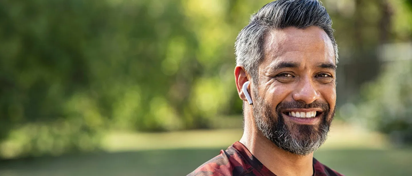 Man smiling with a background of green