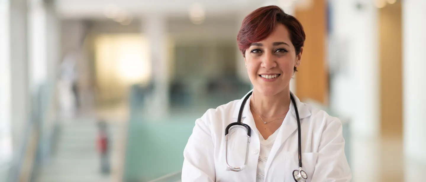 Doctor standing with a hospital hallway in the background