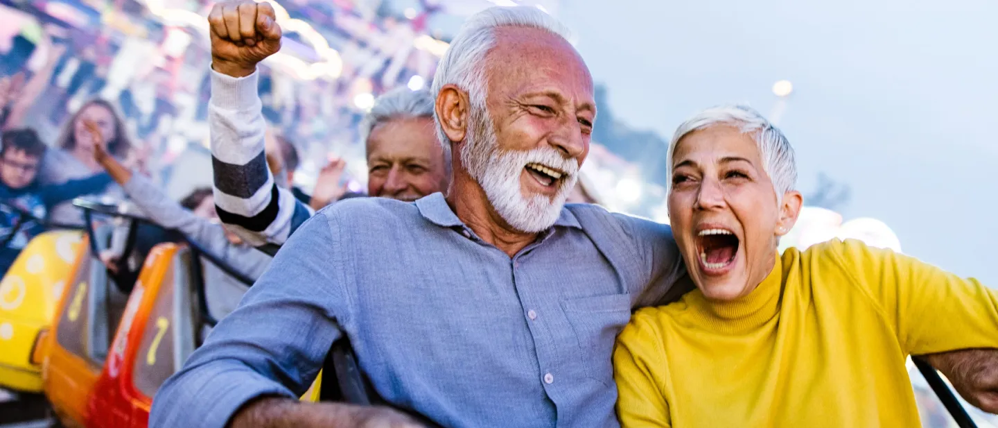 A man and woman smiling on a roller coaster