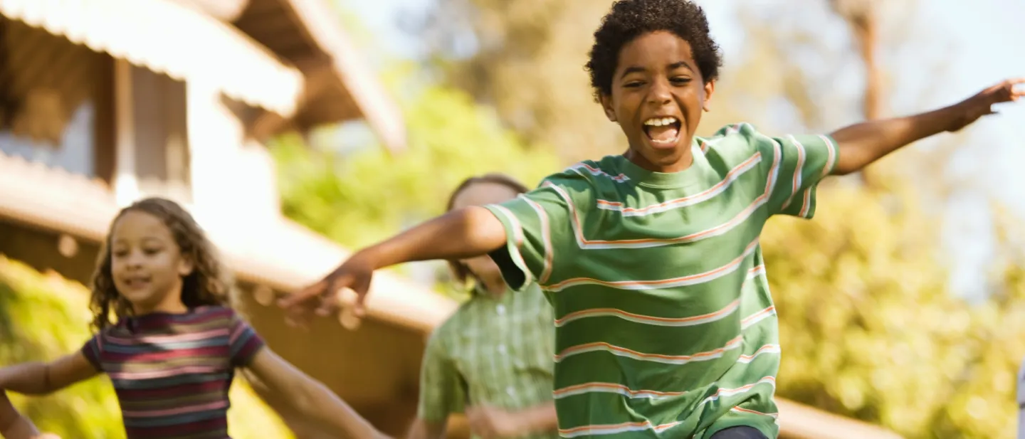 Boy running and playing with two other children