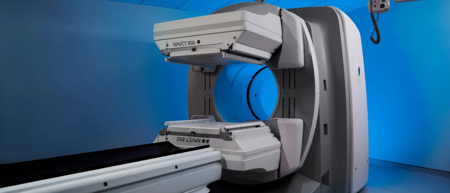 Medical imaging scanner with a circular opening in a blue-lit clinical room