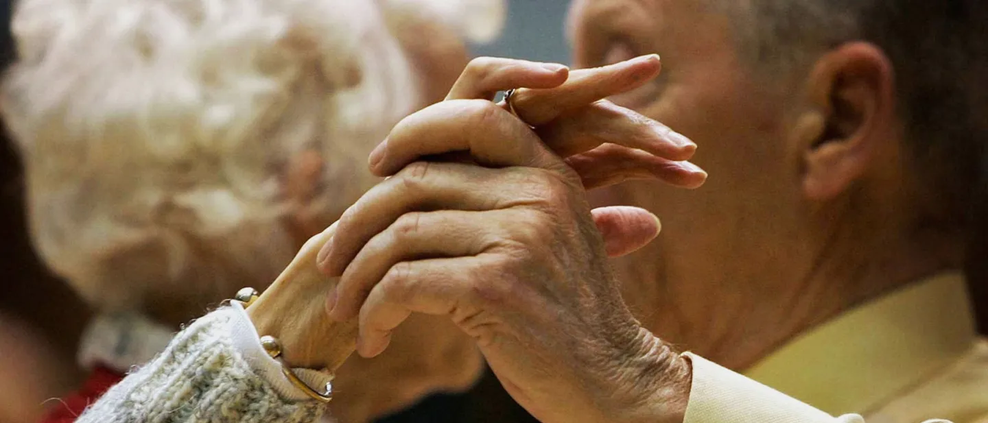 Elderly couple holding hands dancing