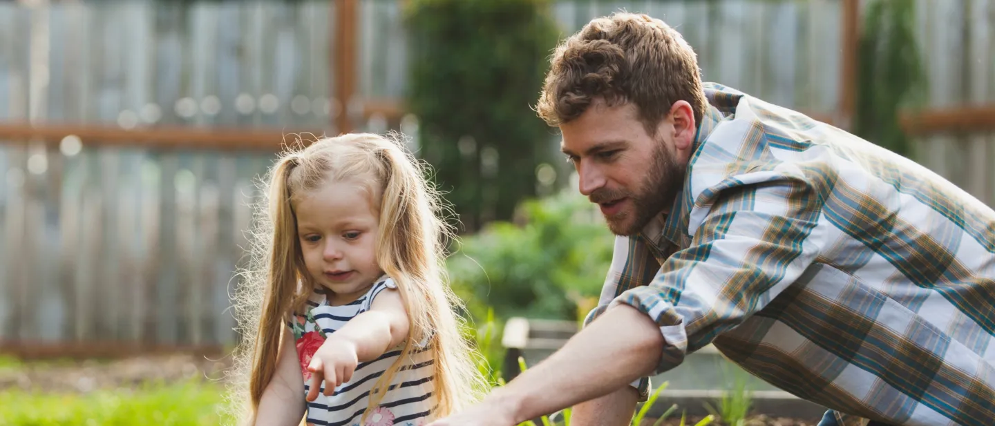 Young girl in the yard with her father.