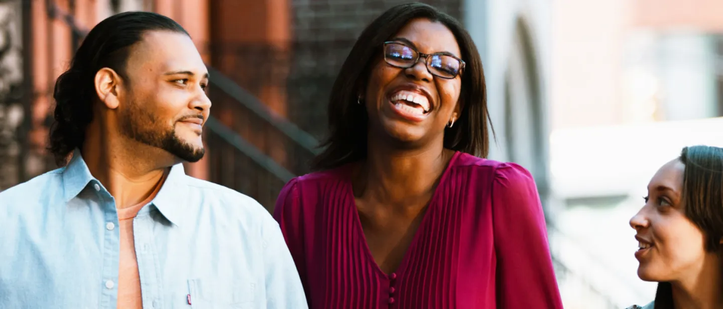 woman laughing in front of stoop, while friends look on
