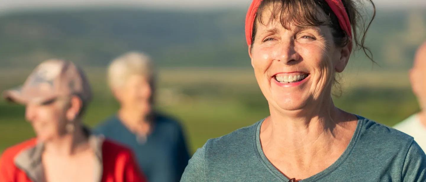 Woman smiling with two other people in the background