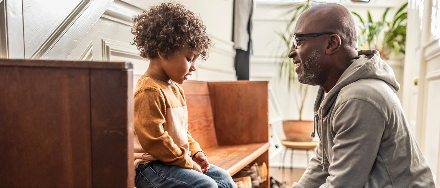 Man kneeling next to boy