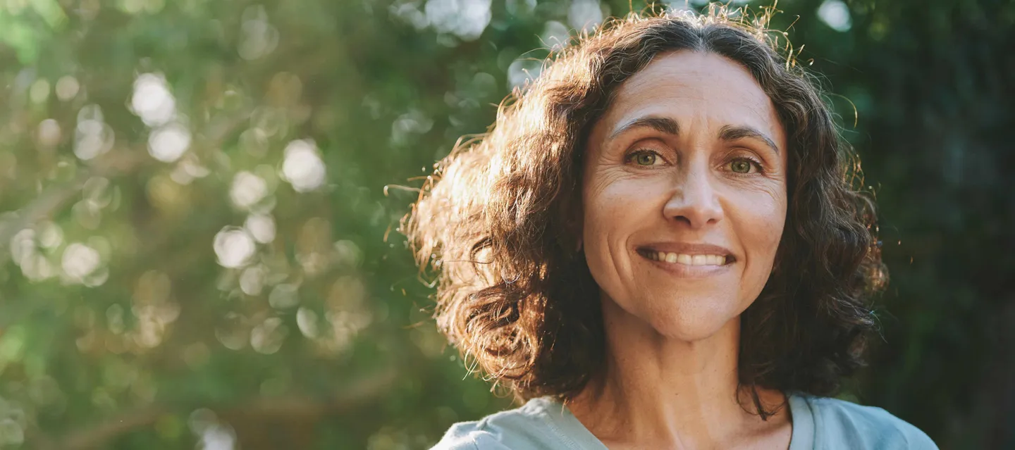 Woman smiling while standing in the sunlight