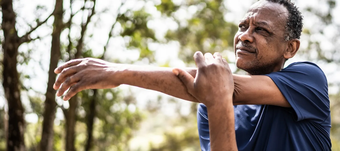 Middle aged man stretching his shoulder and arm