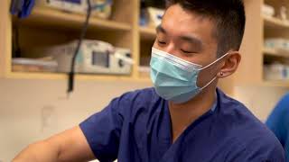A resident wearing scrubs and a surgical mask