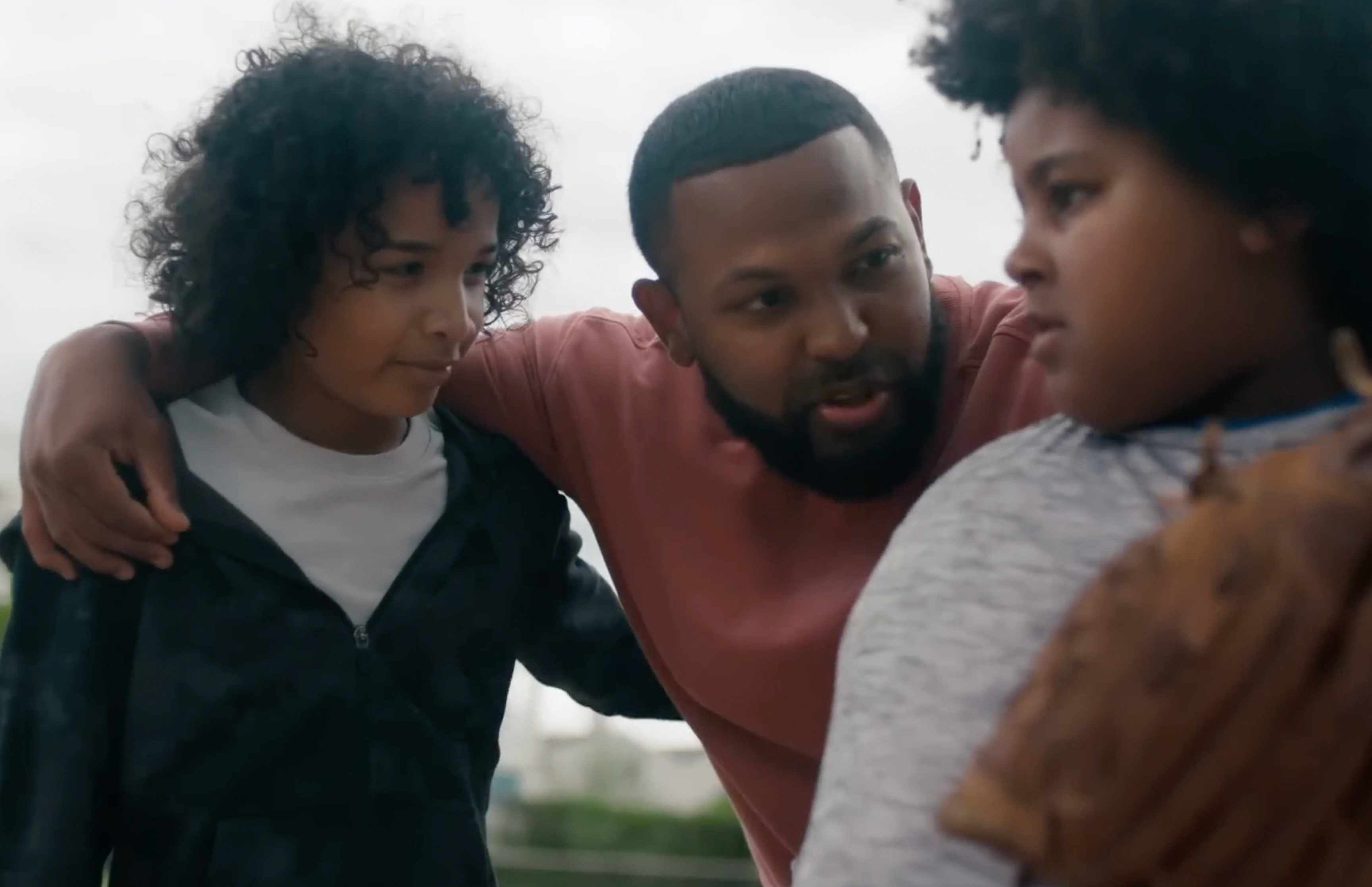 Father gathered with kids playing baseball