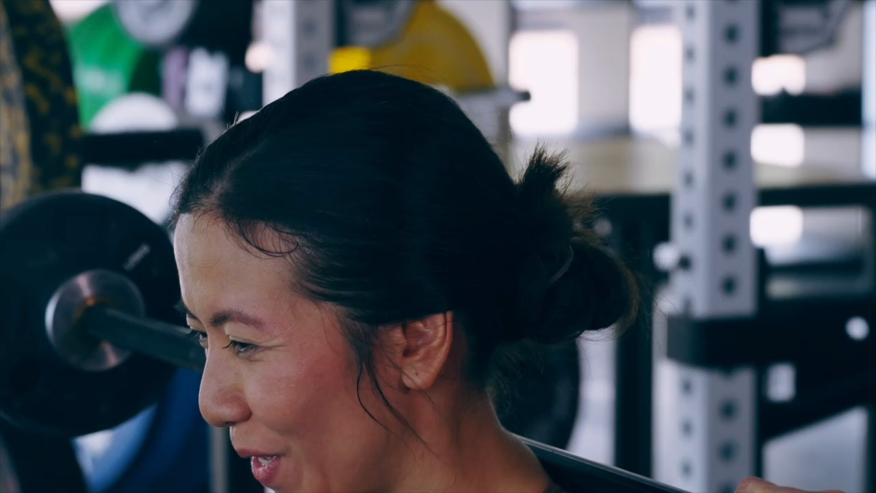 A woman smiling in the gym while exercising 