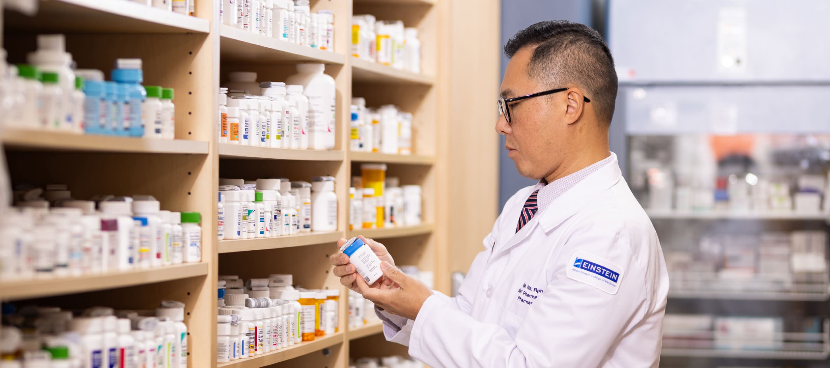 Pharmacy teck looking at prescription bottle