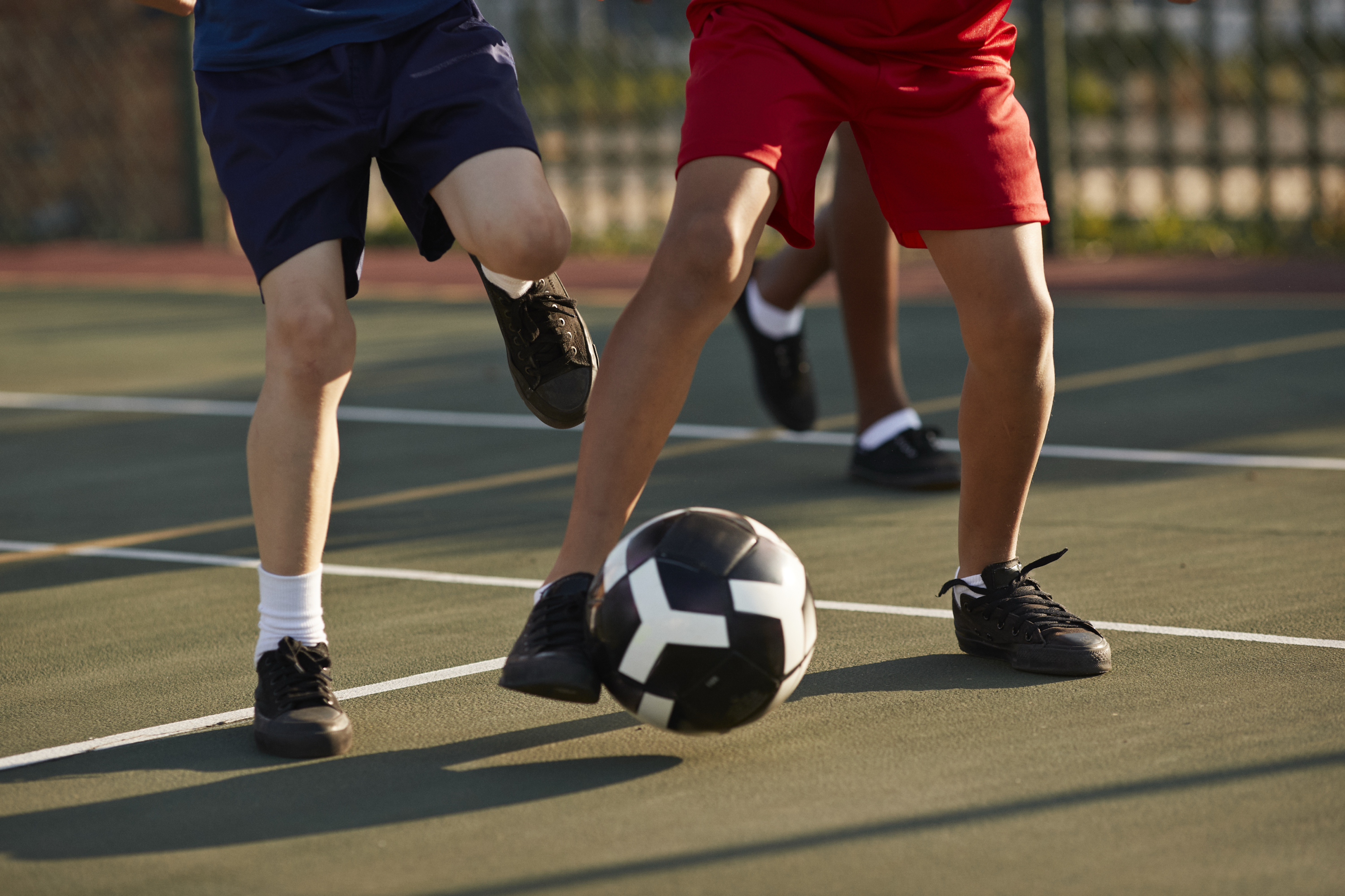 The legs of two men playing soccer