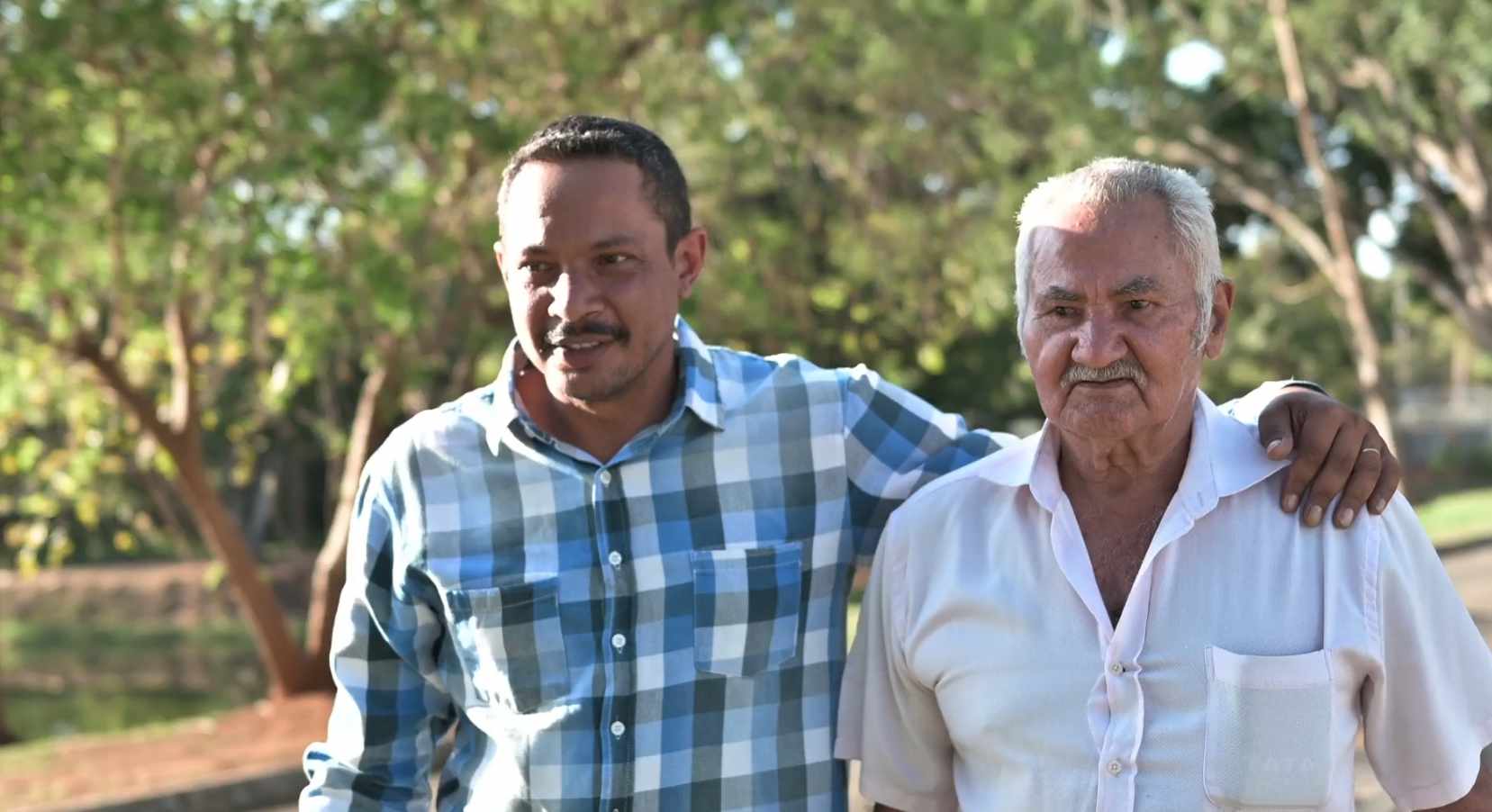 Young man and elderly man walking in the park