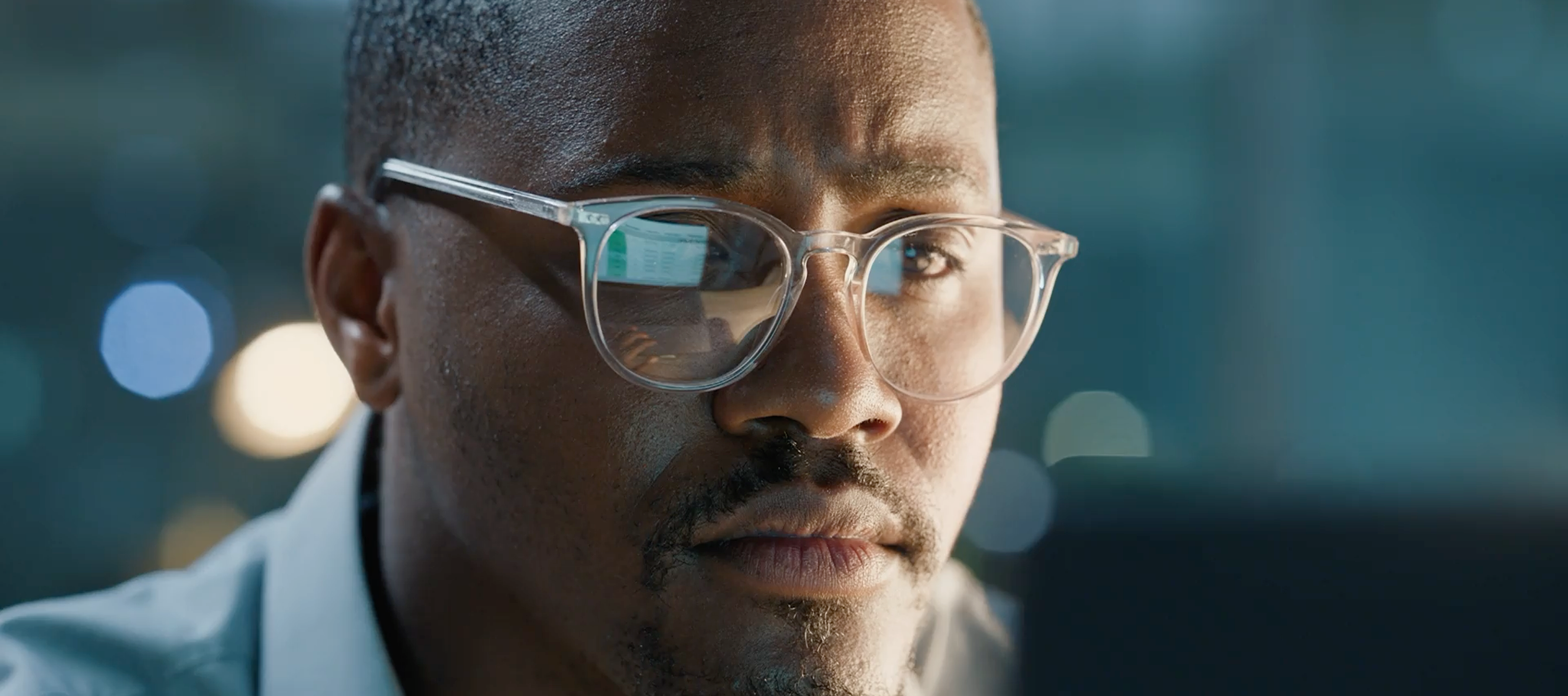 Man wearing glasses looking at a computer screen