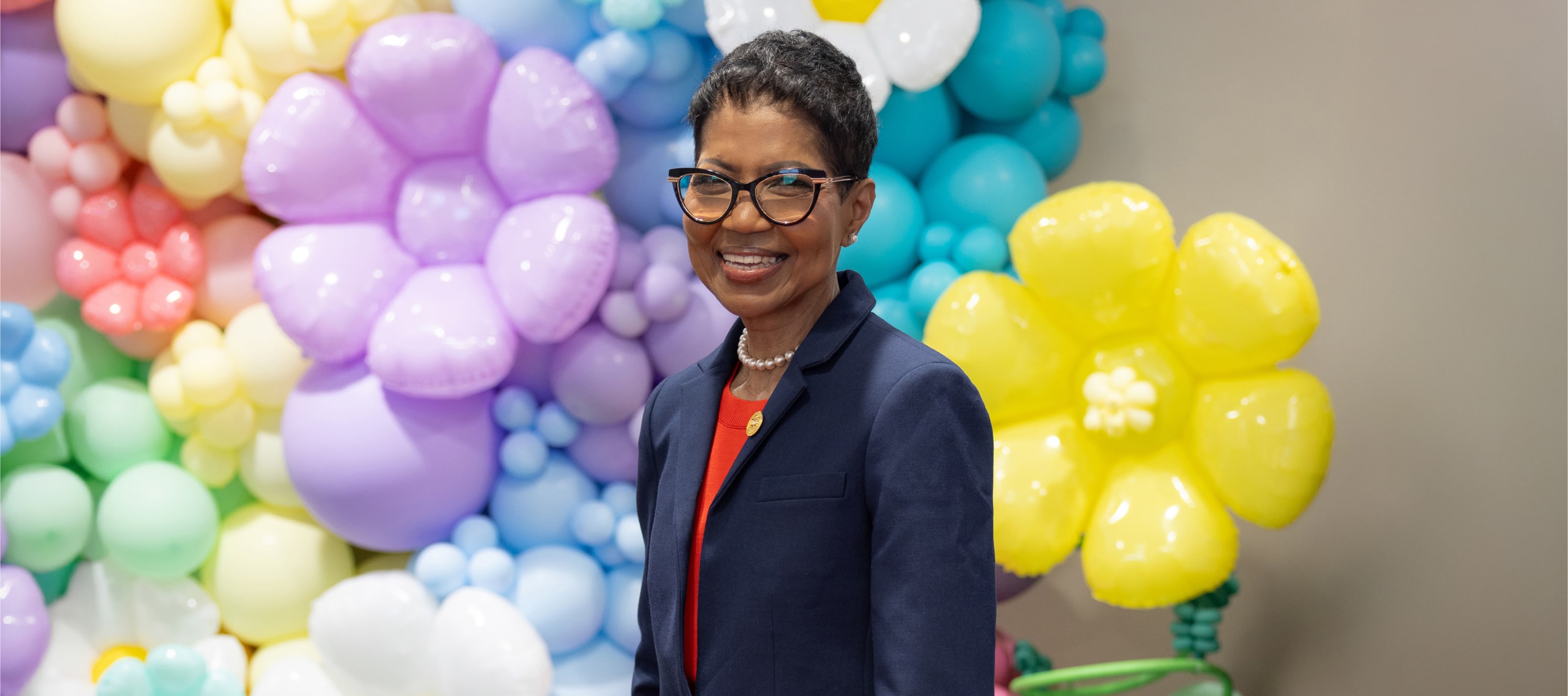 Woman nurse posing with ballon arrangement behind her.