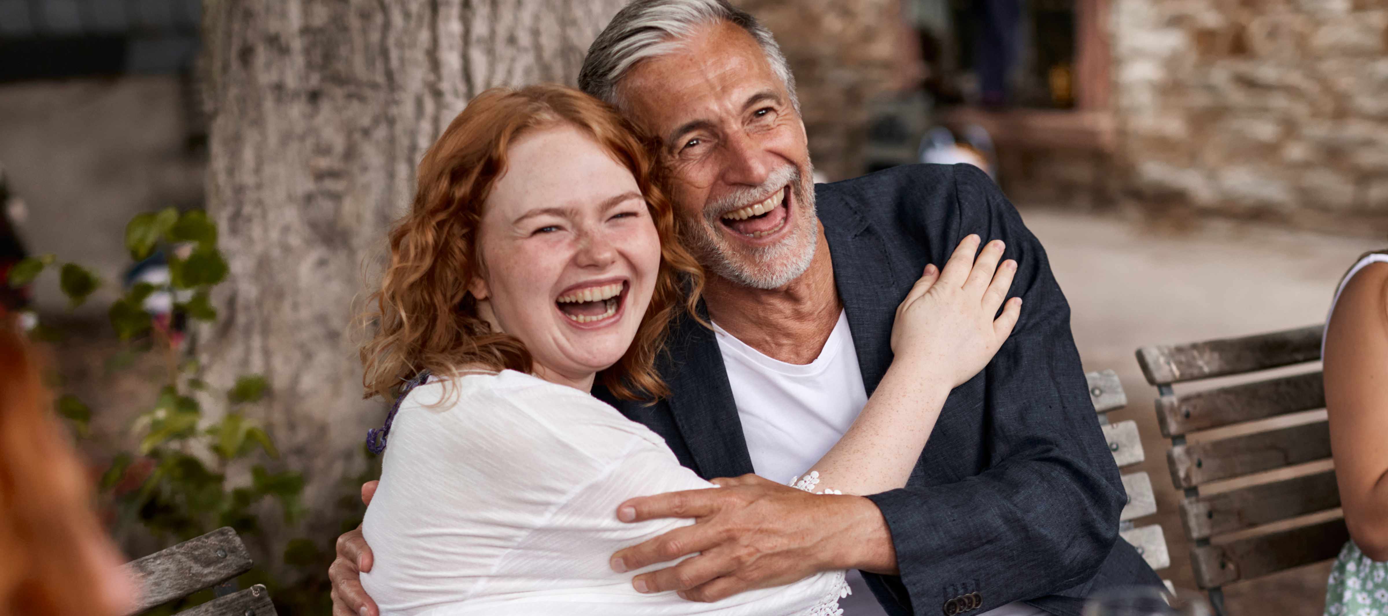 Couple seating on a park bench laughing