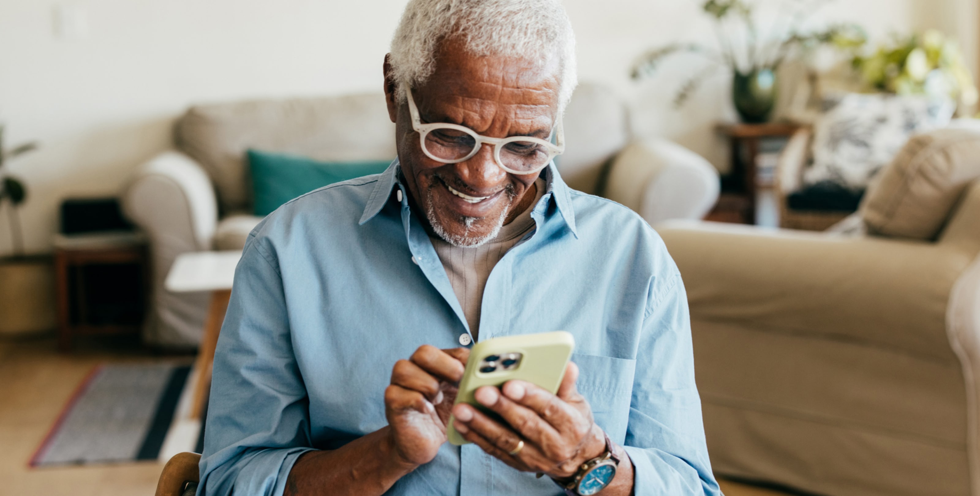 Man wearing glasses and looking at his mobile phone