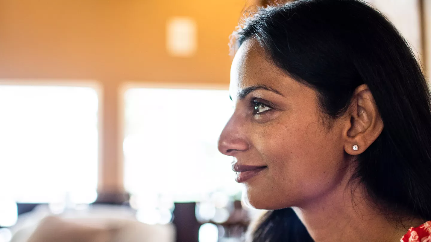 Woman looks off to side smiling.