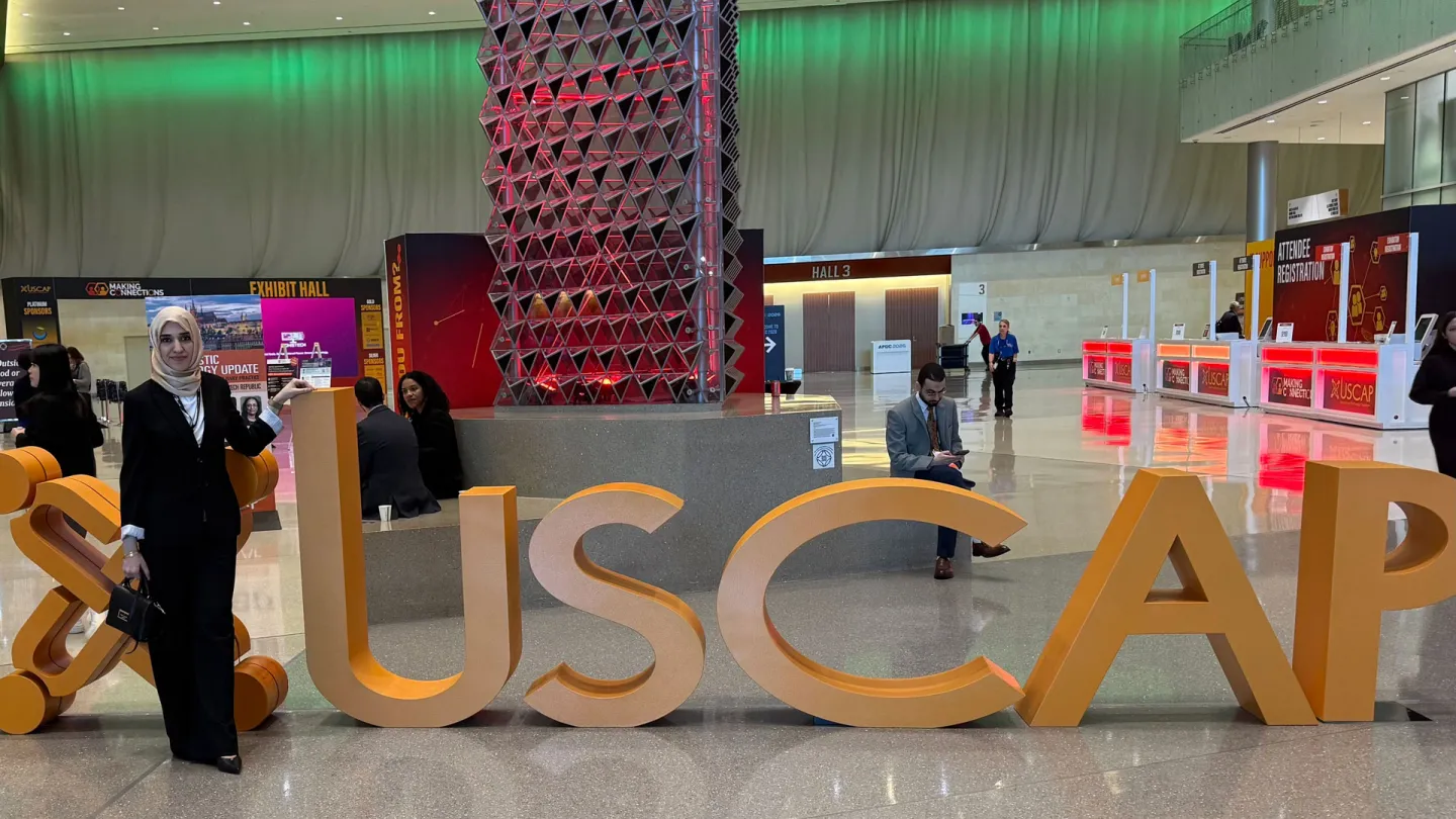 Ahlam Ali in front of the USCAP Sign