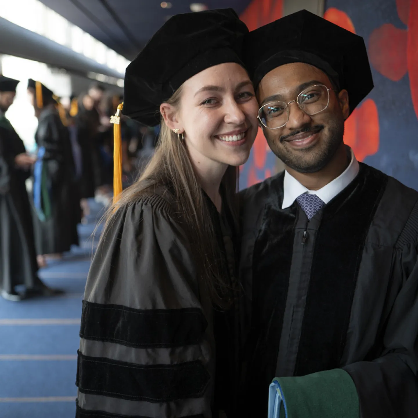 female and male student posing at graduation