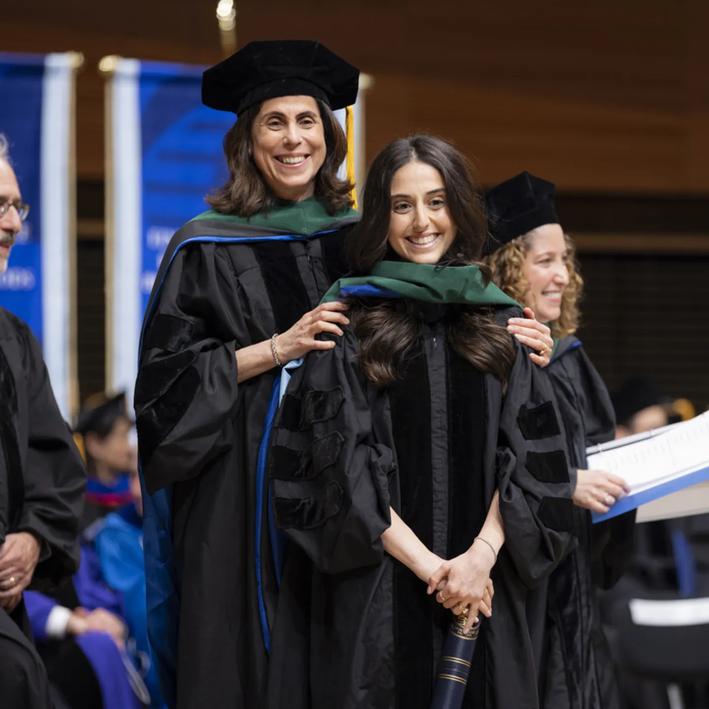 student being hooded by mentor