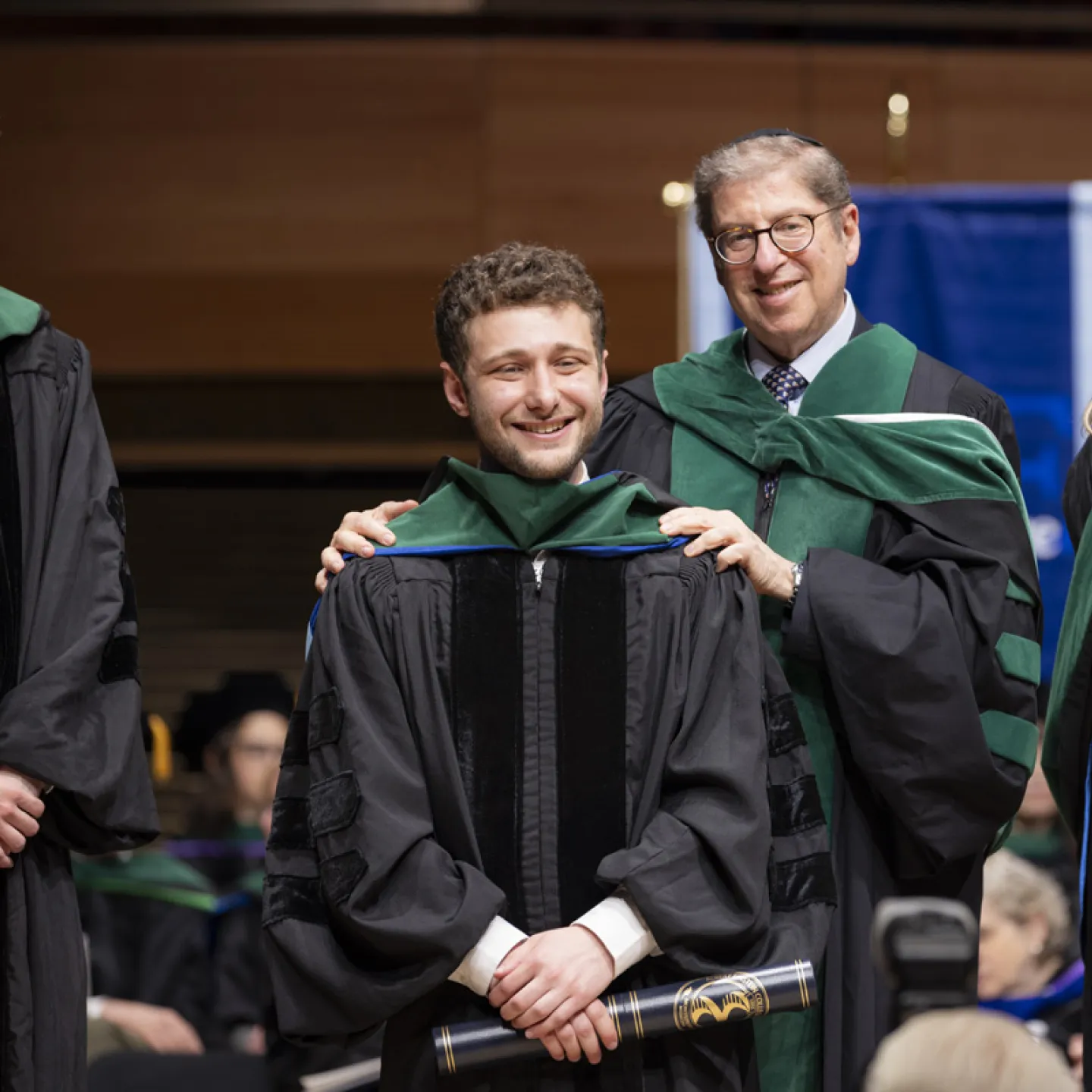 student being hooded by Ed Burns.