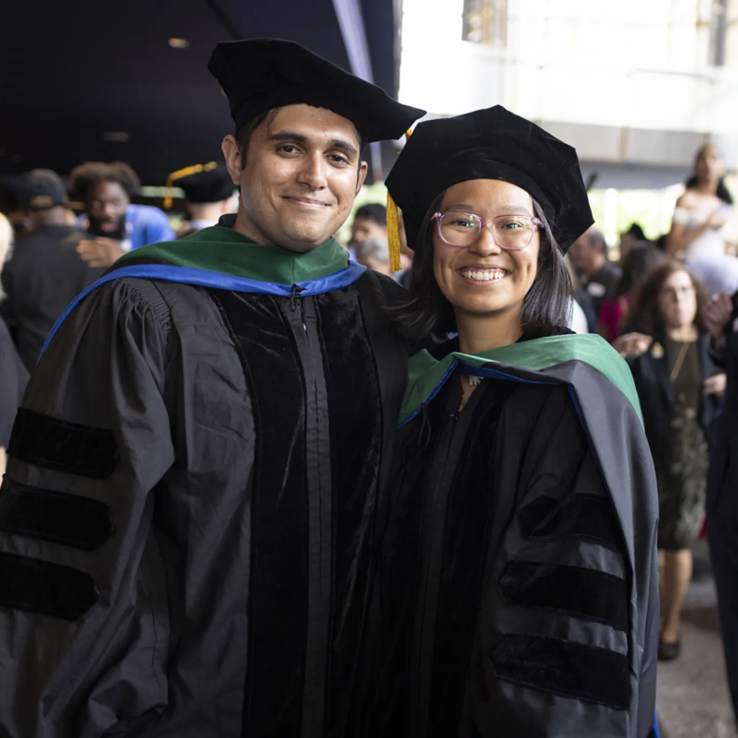 two students posing at graduation