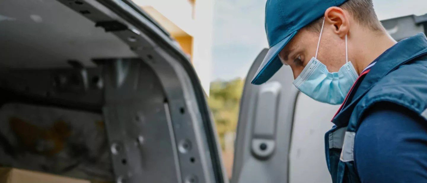 Service technician looking into car