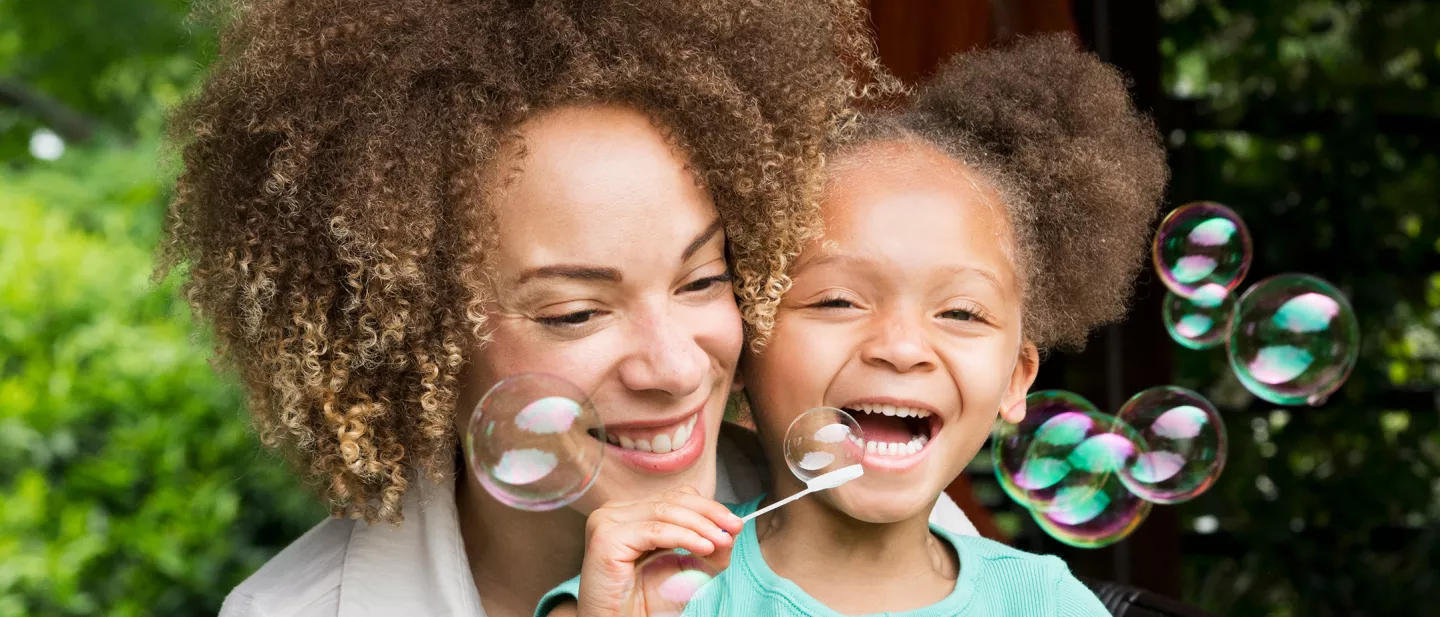 Mother and daughter blowing bubbles