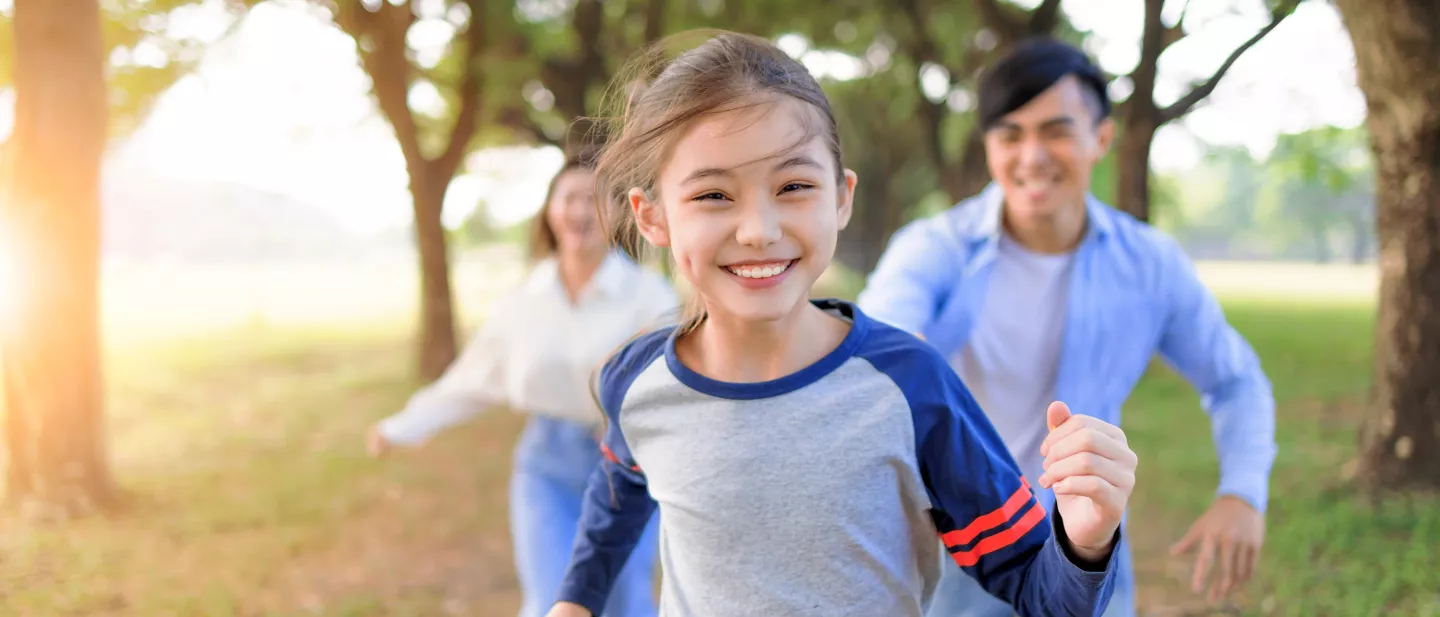A family running and playing together in the park