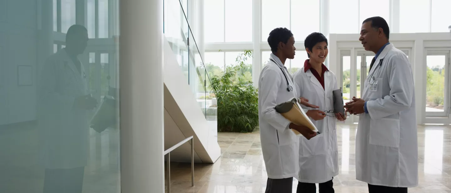 Physicians in a sunny modern lobby in discussion