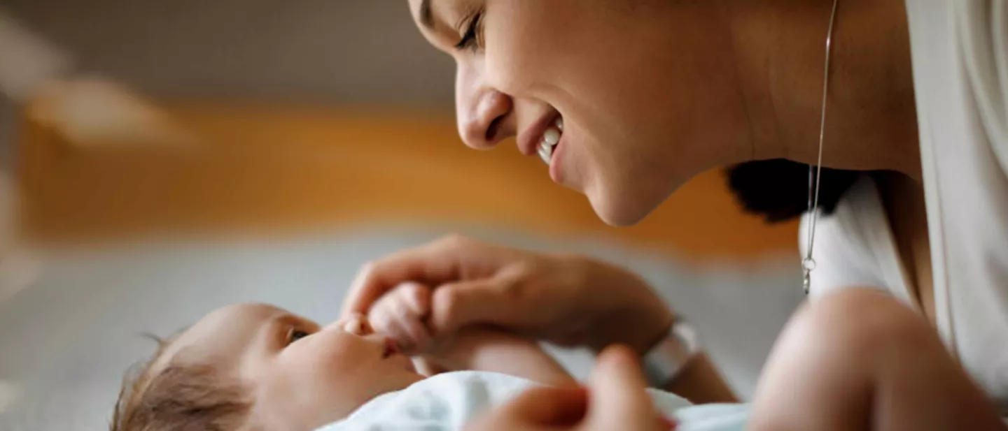 Mother smiling at her new born baby