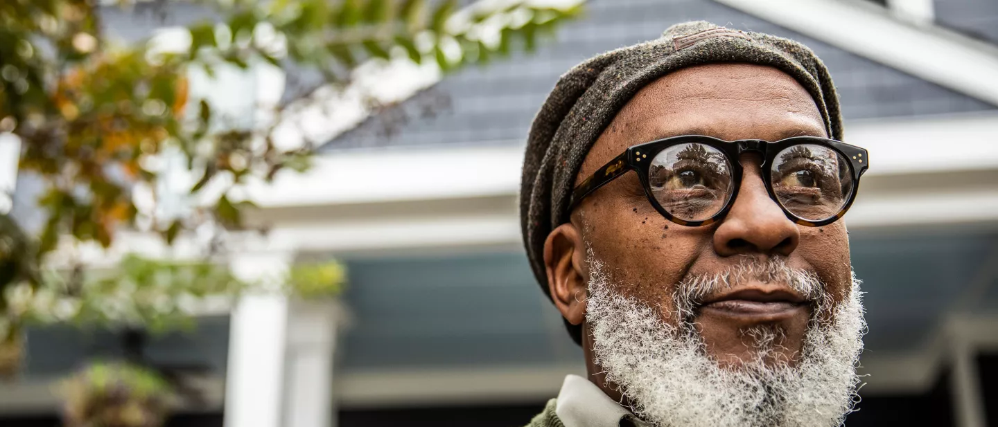 Portrait of senior man in front of suburban home