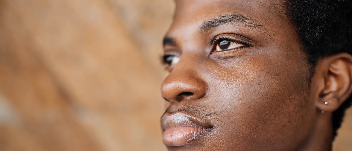 Close-up of a young person looking ahead with a thoughtful expression.