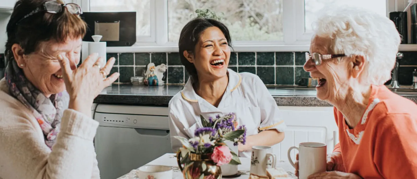 Three women laughing in the kitchen