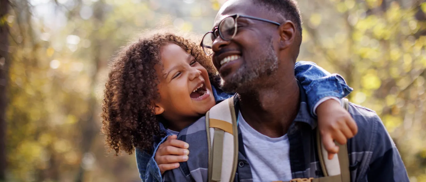 Happy dad with his little girl on his back