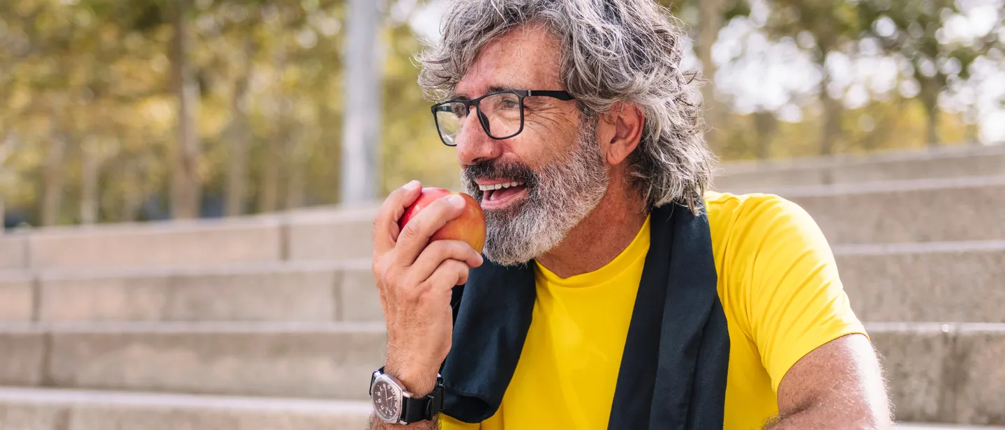 Man wearing glasses and eating an apple