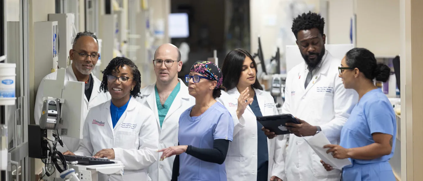 Group of nurses exchanging notes in a hospital corridor