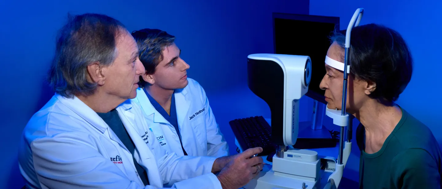 Two eye doctors perform a vision test on a patient