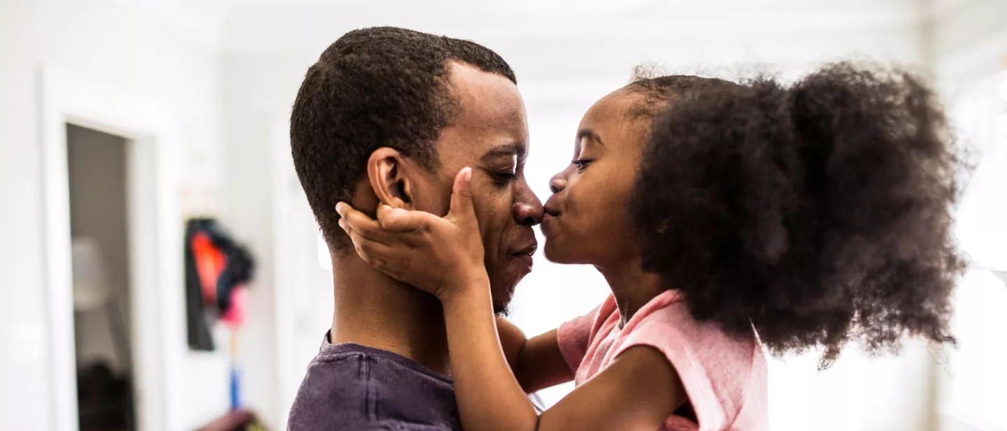Father enjoying the kiss of his daughter.