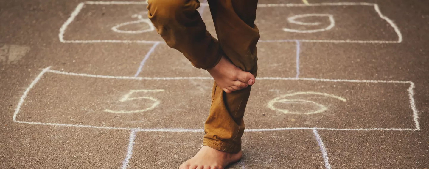 A boy playing hopscotch on a playground