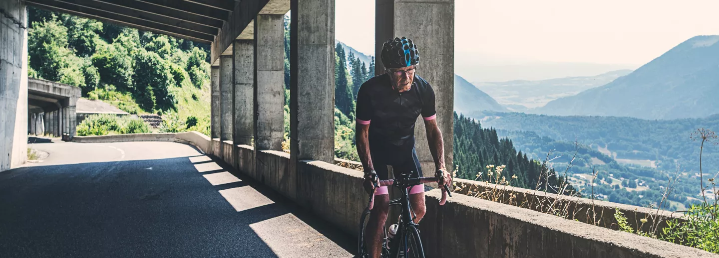  An older male cyclist riding through an Alpine tunnel.