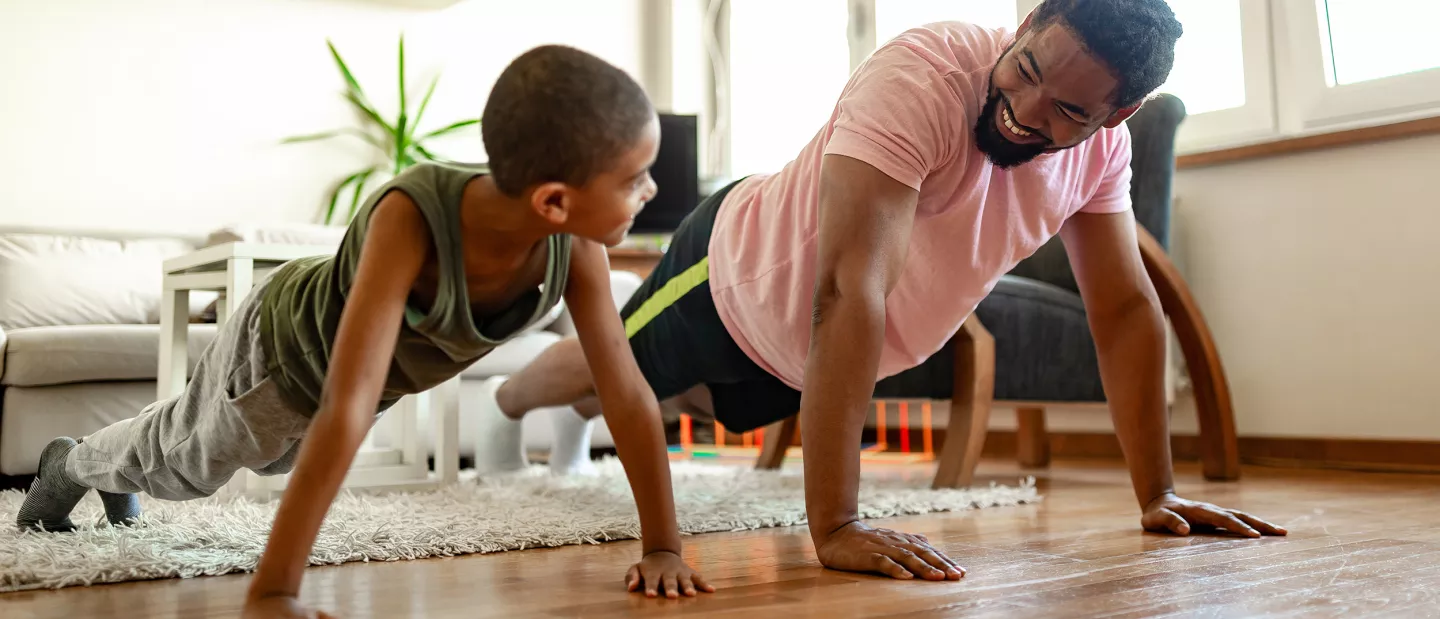 A father and son exercising at home.