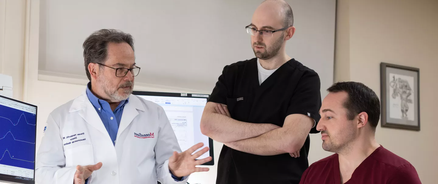 A physician and fellows having a discussion in a hospital room