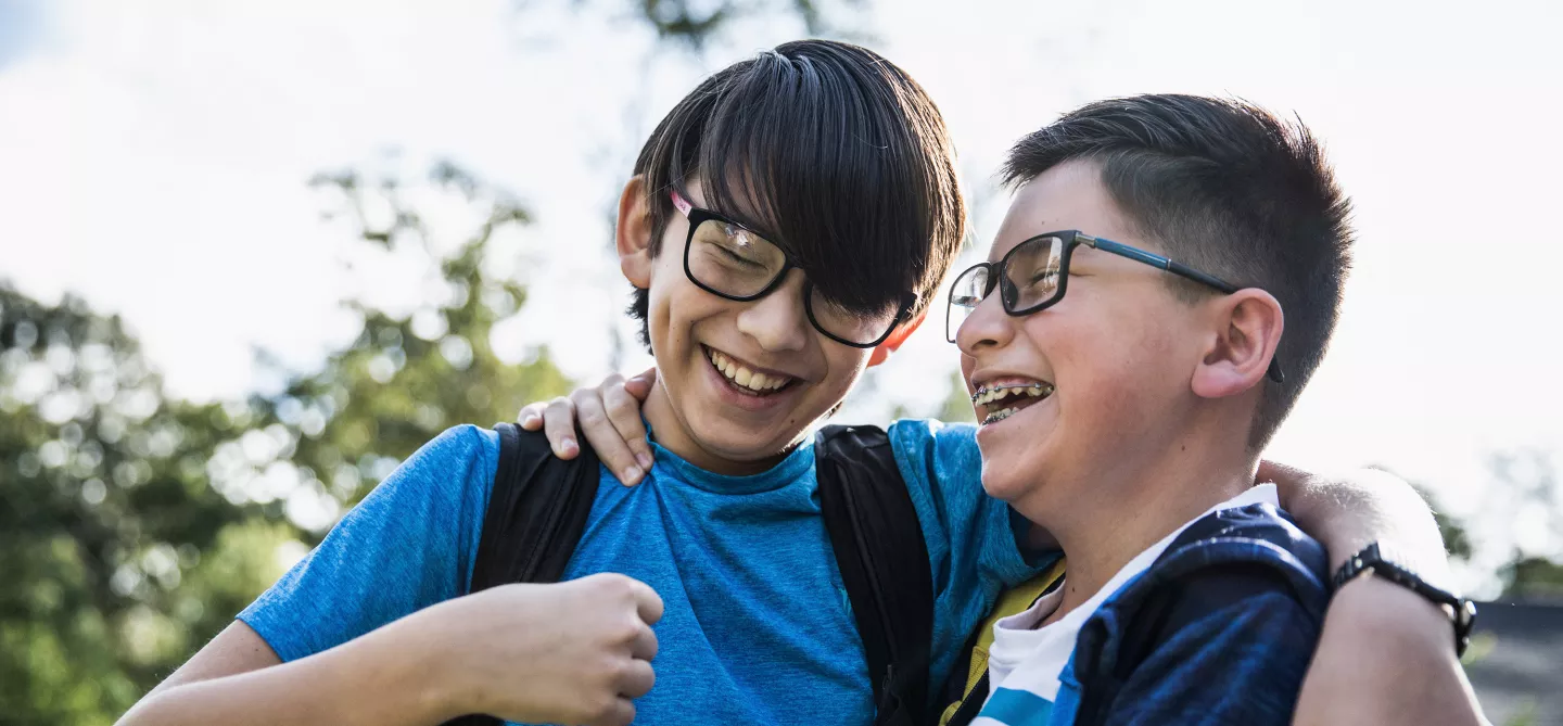 School age brothers laughing outdoors