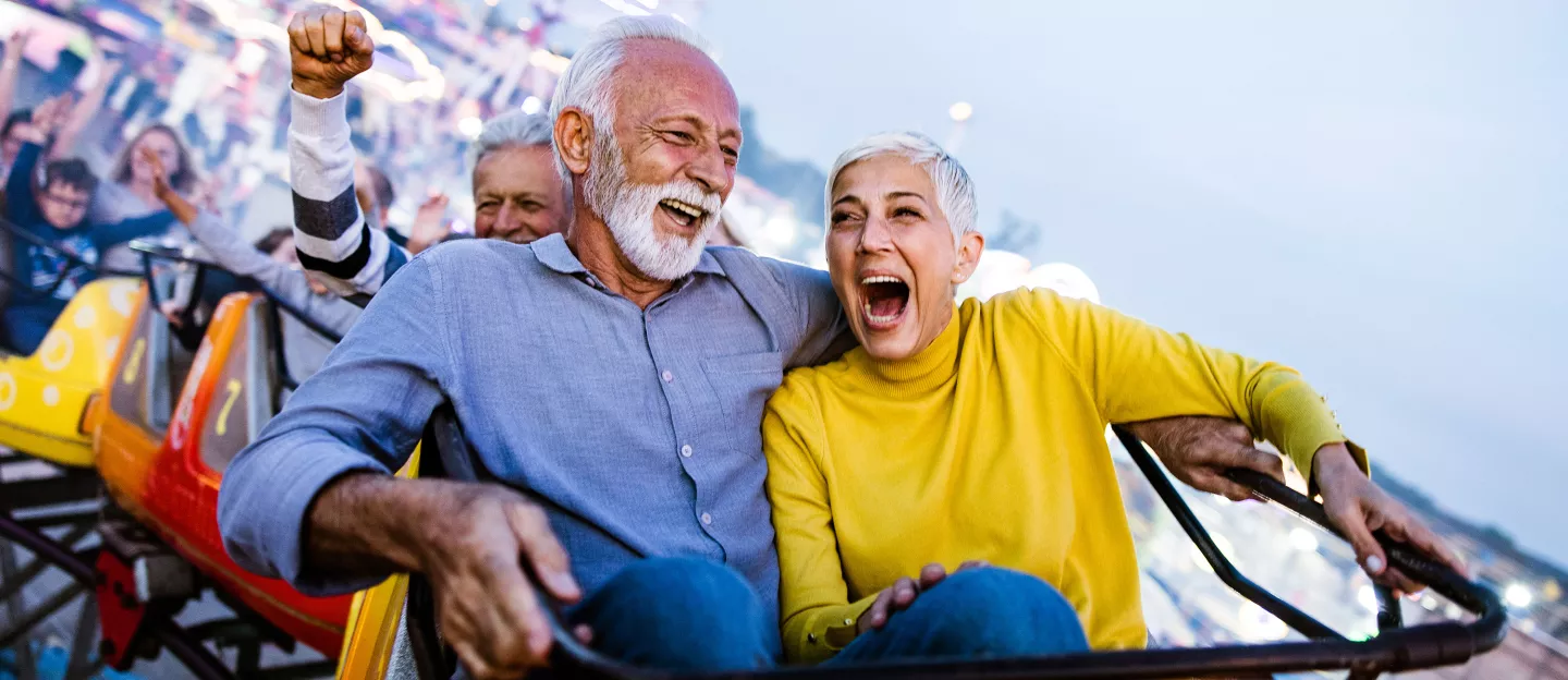 An older couple riding a roller coaster