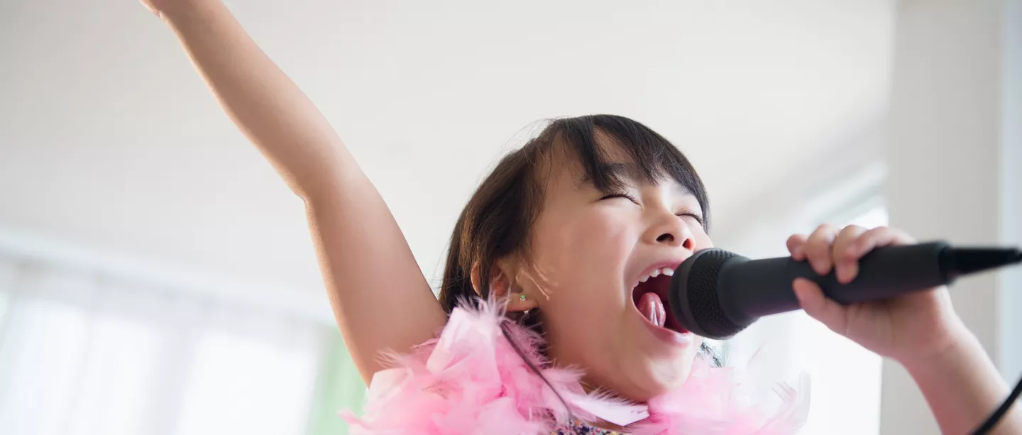 Girl singing karaoke in living room 