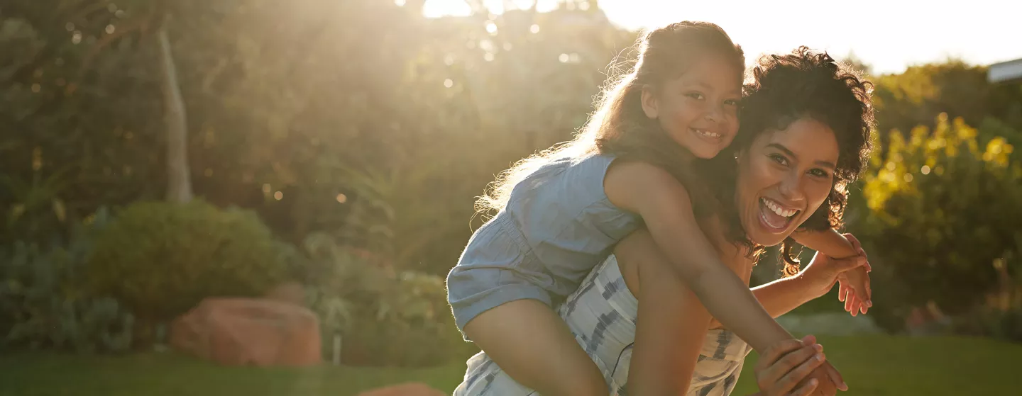 Mother and daughter playing and laughing in their garden