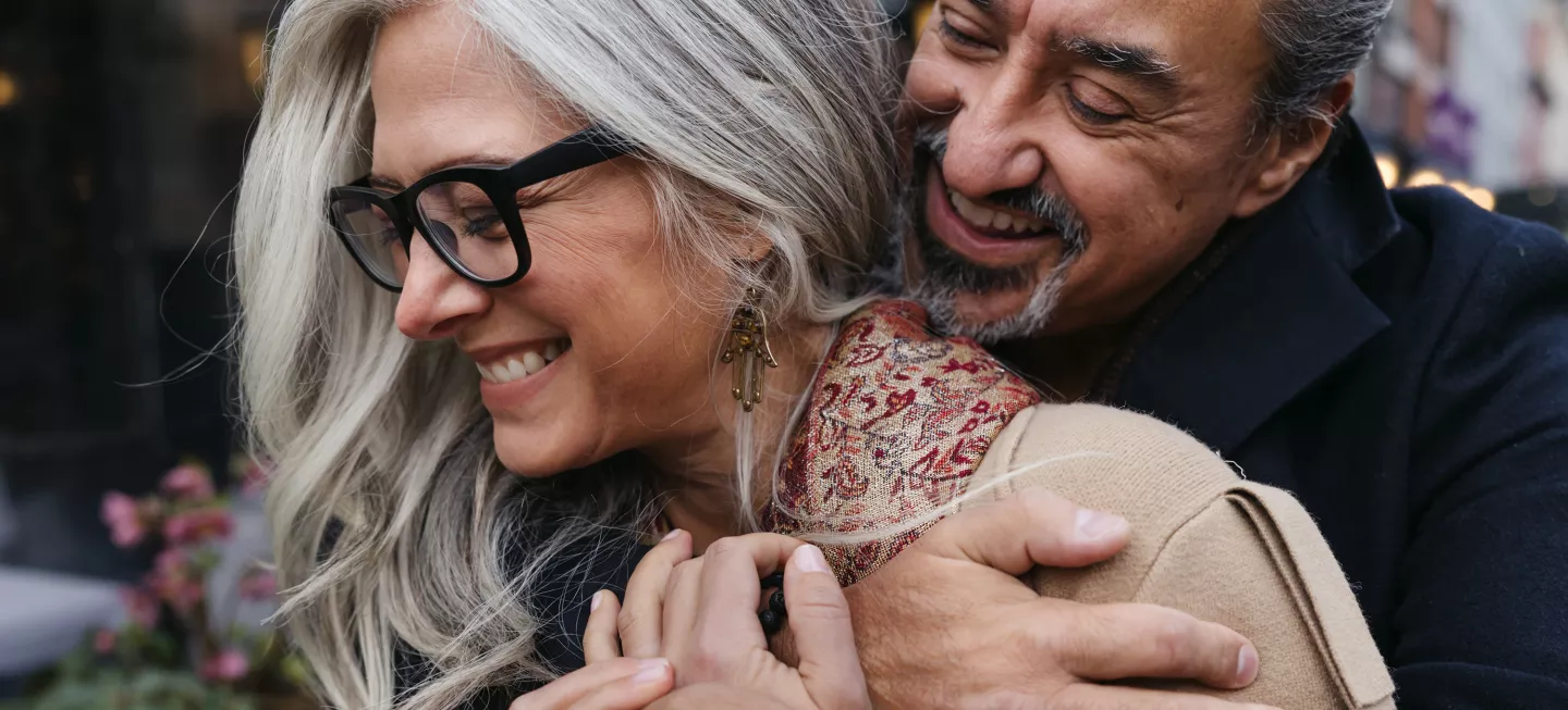A happy couple smiling while embracing